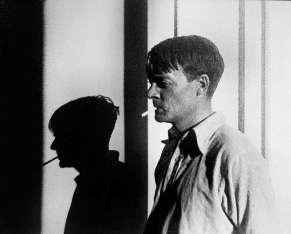 Black-and-white portrait of Eric Ravilious smoking, his shadow cast on a wall